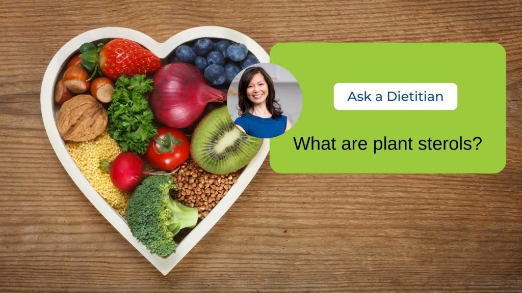 A white heart-shaped bowl filled with heart healthy foods such as nuts, broccoli, kiwi and blueberries. A headshot of Sue is within the image with the caption reading "Ask a Dietitian."
