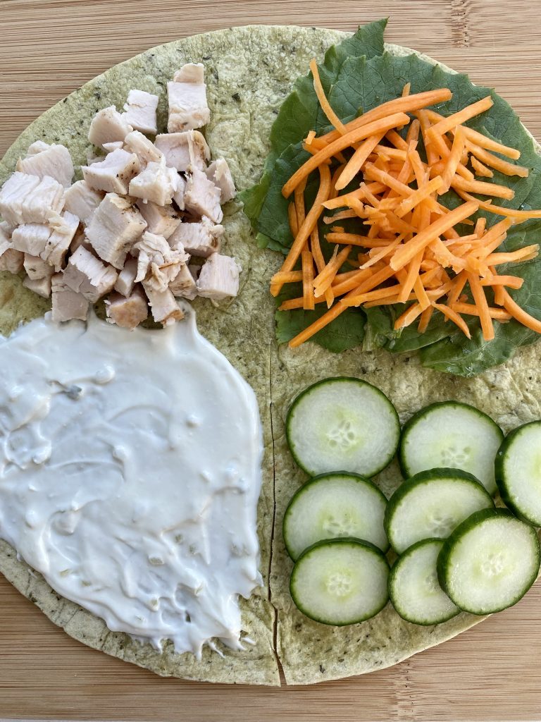 Open faced tortilla with Tzatziki sauce, diced chicken, lettuce, carrots and cucumbers 