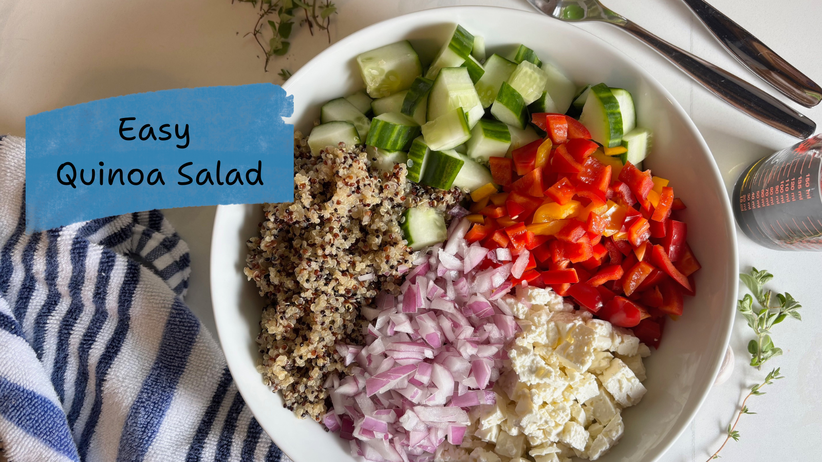 A bowl with quinoa, cucumbers, red peppers, red onion and feta cheese
