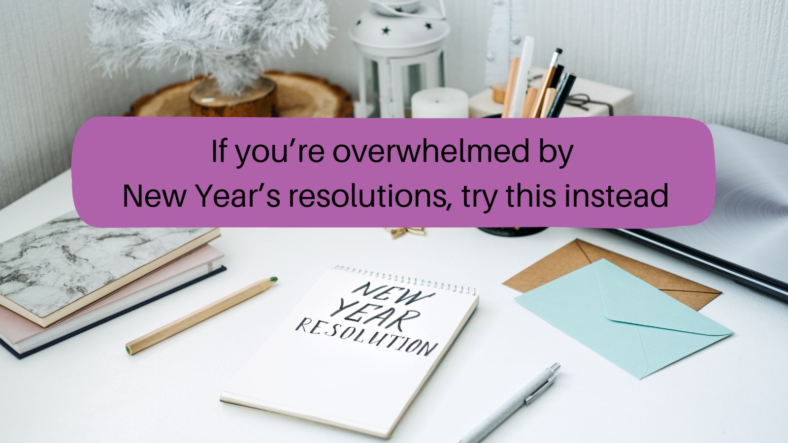 A pad of paper on a desk. The words "New year resolution" are written on the pad of paper. 