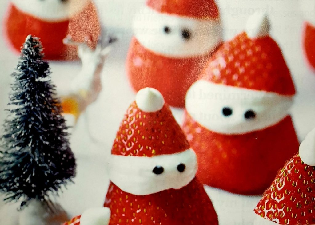 Mini Santas made from sliced strawberries and whipped cream.