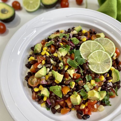 Bean, corn and avocado salad in a large white platter