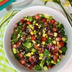 A bowl of black bean salad with corn, tomatoes and avocado
