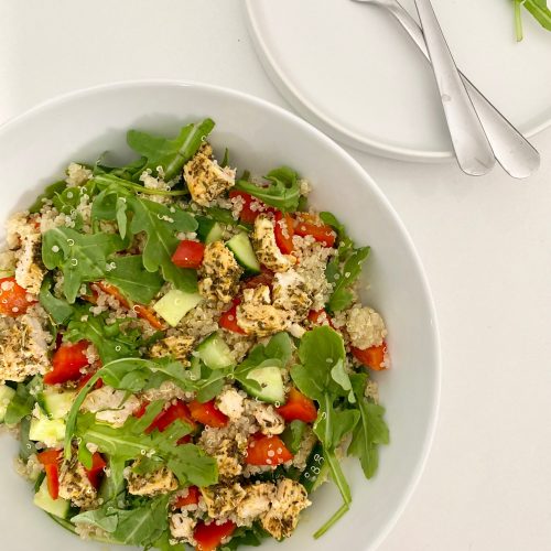 Chicken Quinoa Salad in a white bowl with 2 small white side plates